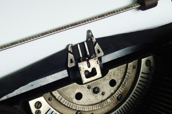 Satzzeichen nach Stichpunkten: Schwarze Schreibmaschine mit eingespanntem, noch leeren Blatt Papier